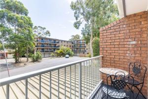 a balcony with a table and a brick wall at 110 Catalina Close so close to the water in Shoal Bay