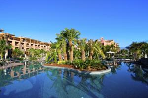 una gran piscina de agua con palmeras y edificios en Lopesan Baobab Resort, en Meloneras