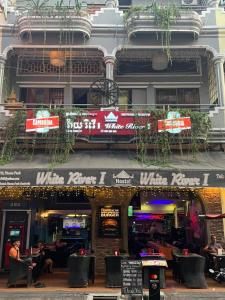 a building with a restaurant with people sitting outside at White River guesthouse in Phnom Penh