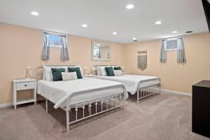a bedroom with two beds with white and green pillows at Unique 4 Season Porch 6 Queen Beds HUGE Space in Rapid City