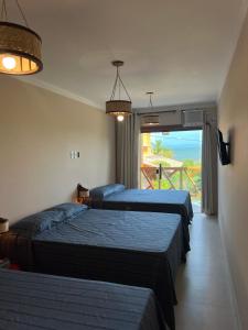 two beds in a room with a view of the ocean at Recanto Bela Vista II in Costa Dourada