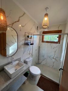 een badkamer met een wastafel, een douche en een toilet bij Recanto Bela Vista II in Costa Dourada