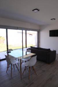 sala de estar con mesa, sillas y sofá en Casa 3 ambientes - FARO NORTE - en Mar del Plata