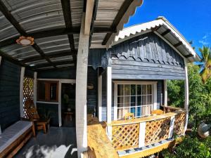 een houten veranda met luifel op een huis bij Rustic House Punta Rucia in Punta Rucia