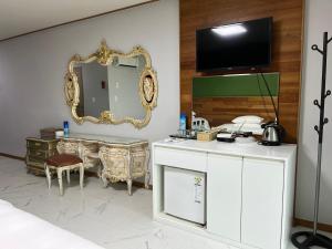 - une chambre avec un miroir et une commode blanche dans l'établissement Hill Hotel, à Jeju