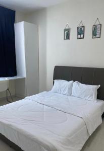 um quarto com uma cama grande e lençóis brancos em Trails of Kampar em Kampar