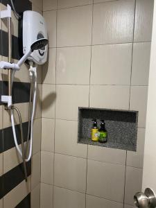a bathroom with a shower with two bottles on a shelf at Trails of Kampar in Kampar