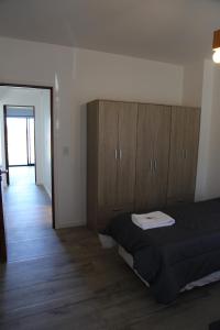 een slaapkamer met een bed en houten kasten bij Casa 3 ambientes - FARO NORTE - in Mar del Plata
