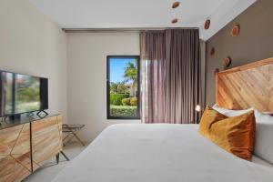 ein Schlafzimmer mit einem Bett und einem TV in der Unterkunft Gold Coast Aruba - Aurum Collection in Malmok