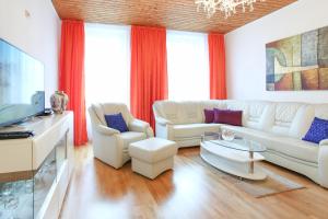 uma sala de estar com mobiliário branco e cortinas vermelhas em Classic Apartment I Close to Main Station I 10 Minutes to Belvedere em Viena