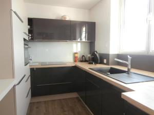 アルカションにあるAppartement Arcachon, 3 pièces, 6 personnes - FR-1-374-59のキッチン(黒いキャビネット、シンク付)