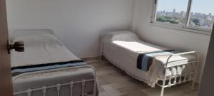 two twin beds in a room with a window at TORRE Rivera in Buenos Aires