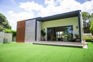 una casa con un césped verde delante de ella en Small, house with golf course view and fresh air 