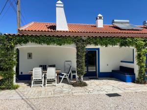a patio with chairs and a table and a building at Inviting holiday home in Montemor o Novo with Pool in Montemor-o-Novo
