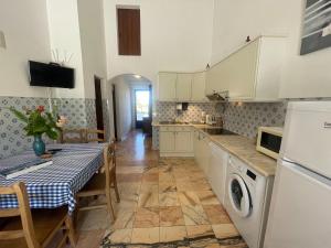 una cucina con armadi bianchi e un tavolo con una tovaglia di Inviting holiday home in Montemor o Novo with Pool a Montemor-o-Novo