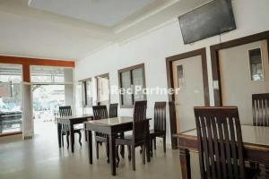 una sala da pranzo con tavolo e sedie di Radja Homestay Mitra RedDoorz a Pipulu