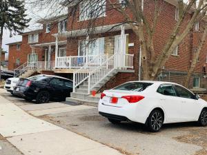 a white car parked in front of a brick house at Full Privacy Apartment with Free Parkrings in Toronto