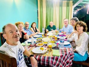 a group of people sitting around a table eating food at Sigiri Saman Home Stay in Sigiriya