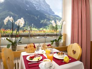 uma mesa com comida para o pequeno almoço e vista para uma montanha em Hotel Bernerhof Grindelwald em Grindelwald