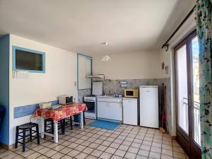 ジュルヴィル・レ・パンにあるAppartement Jullouville, 3 pièces, 4 personnes - FR-1-361-30のキッチン(白い家電製品、赤いテーブル付)