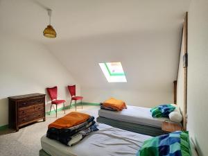 ジュルヴィル・レ・パンにあるAppartement Jullouville, 3 pièces, 4 personnes - FR-1-361-30のベッドルーム1室(ベッド2台、赤い椅子2脚付)