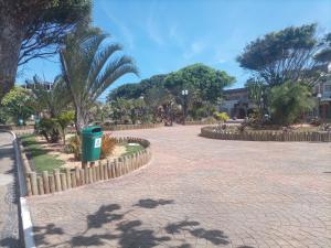 un parque con palmeras y un cubo de basura en SUITES VISTA MAR AZUL en Saquarema