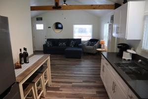 a kitchen and a living room with a black couch at The Blue Lake Cabin! 1 min Walk to SnowPlay! in Big Bear City