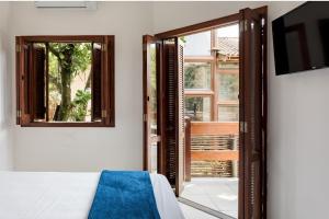 um quarto com uma cama e uma porta de vidro deslizante em Afras Maresias em São Paulo
