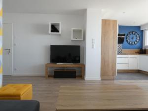 een woonkamer met een flatscreen-tv en een tafel bij Appartement Saint-Jean-de-Monts, 3 pièces, 5 personnes - FR-1-323-230 in Saint-Jean-de-Monts