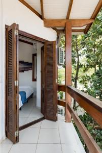 una puerta abierta a un balcón con cama en Afras Maresias en São Paulo