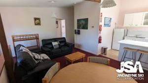 a living room with a couch and a table at Mistral 2 in Jindabyne
