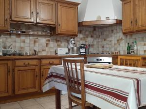 uma cozinha com armários de madeira e uma mesa com uma toalha de mesa em Maison Seignosse, 5 pièces, 8 personnes - FR-1-239-600 em Seignosse