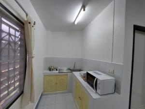 a small kitchen with a microwave and a sink at U53/37 in Koh Samui