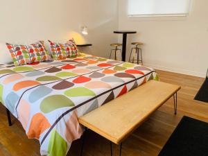 a bed with a colorful comforter and a wooden bench at Dragonfly Motor Lodge in Panguitch