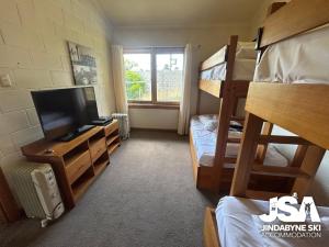 a room with two bunk beds and a television at Moonbah 2 in Jindabyne
