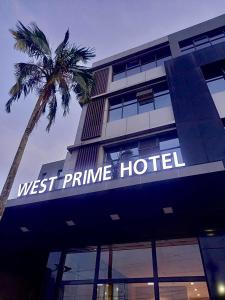 un bâtiment avec un palmier en face dans l'établissement West Prime Hotel, à Calbayog