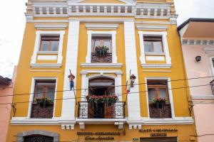 a yellow building with flowers on the balconies at Hotel Colonial San Agustin in Quito