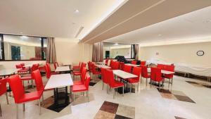 restauracja z czerwonymi krzesłami i stołami w pokoju w obiekcie Zhongshan Boutique Hotel w mieście Kaohsiung