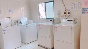 a laundry room with white appliances and a window at Zhongshan Boutique Hotel in Kaohsiung