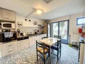 a kitchen with a table and chairs in a room at Villa proche Plage et Centre, Jardin Clos, Wifi, Chien possible - FR-1-361-431 in Jullouville-les-Pins