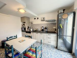 a kitchen with a table and a refrigerator at Villa proche Plage et Centre, Jardin Clos, Wifi, Chien possible - FR-1-361-431 in Jullouville-les-Pins +27 photos
