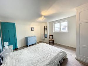 a bedroom with a bed and a blue door at Villa proche Plage et Centre, Jardin Clos, Wifi, Chien possible - FR-1-361-431 in Jullouville-les-Pins