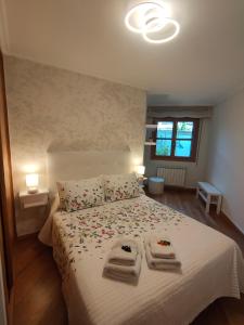 a bedroom with a bed with two towels on it at Apartamento Pontevedra centro HOMYHOME II in Pontevedra
