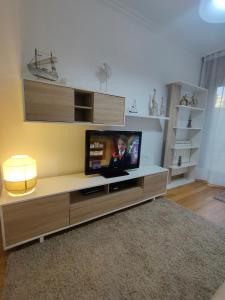 ein Wohnzimmer mit einem Flachbild-TV auf einem Entertainment-Center in der Unterkunft Apartamento Pontevedra centro HOMYHOME II in Pontevedra