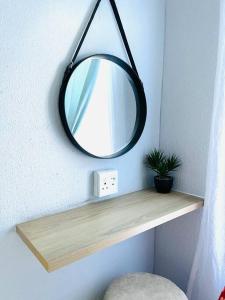 einen Spiegel auf einem Holzregal in einem Zimmer in der Unterkunft Are you travelling to Pretoria? in Pretoria