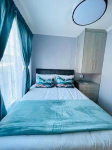 a bedroom with a bed with a blue comforter and a window at Are you travelling to Pretoria? in Pretoria
