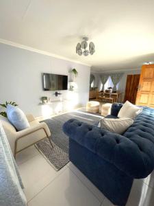 a living room with a blue couch and two chairs at Are you travelling to Pretoria? in Pretoria