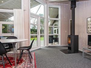 ボルコップにあるHoliday Home Hvidbjergvejのリビングルーム(暖炉、テーブル、椅子付)