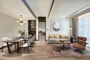 uma sala de estar com uma mesa e um sofá em Oakwood Residence Foshan em Foshan