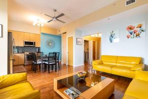 a living room with a yellow couch and a table at A Corner Unit with OCEAN VIEWS from EVERY ROOM in Long Beach